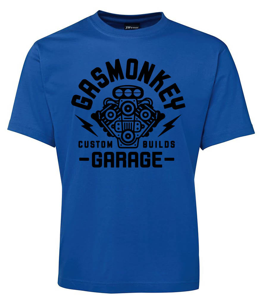 Blue Gas Monkey Garage t-shirt by Corsa Clothing featuring a black engine graphic, GAS MONKEY GARAGE text above and below, and CUSTOM BUILDS with lightning bolts on each side.