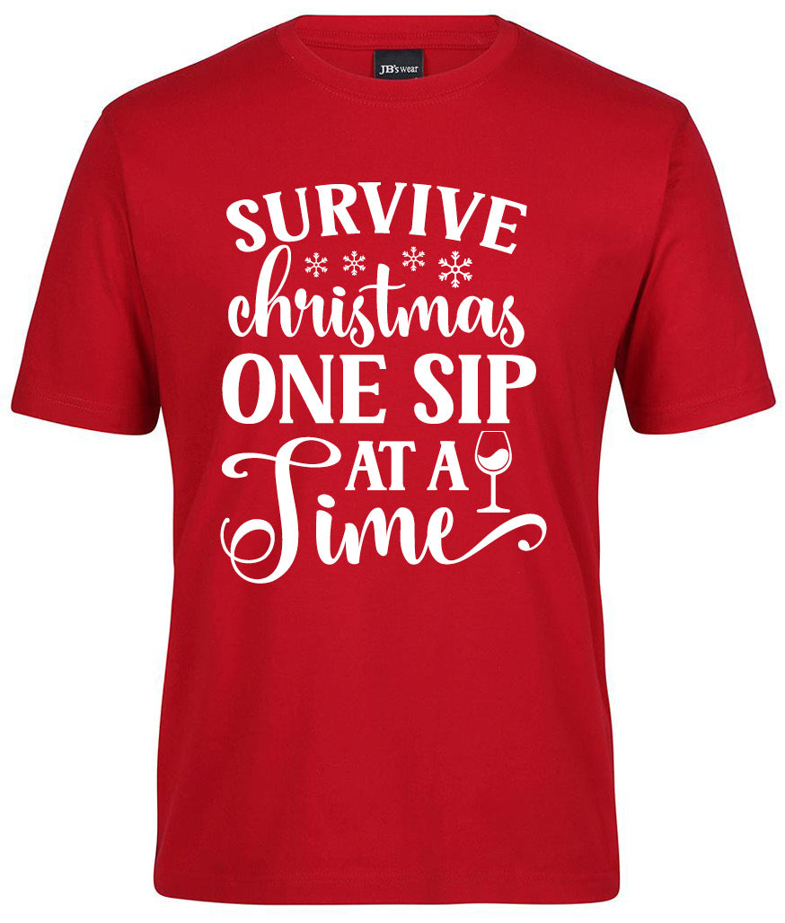 The Corsa Clothing "Survive Christmas one sip at a time Shirt" is a red tee with white text, snowflakes, and a small wine glass illustration.