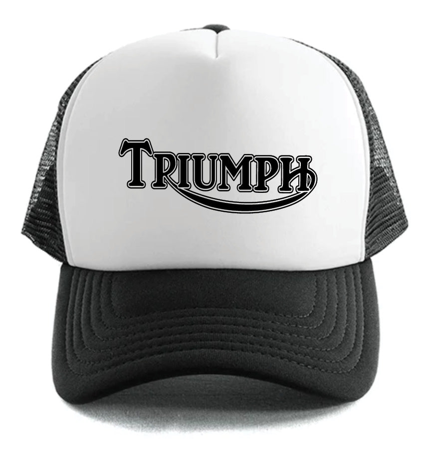 The Corsa Clothing Triumph Classic Logo Hat is a white and black trucker cap with a mesh back and "TRIUMPH" in bold, stylized black letters on the front.