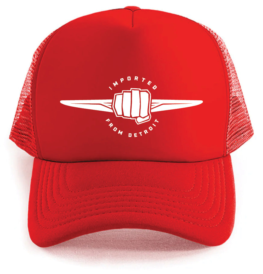 The Chrysler's Debuts Logo Hat by Corsa Clothing is a bright red mesh trucker hat with a white fist logo and "IMPORTED FROM DETROIT" curved around it on the front panel.