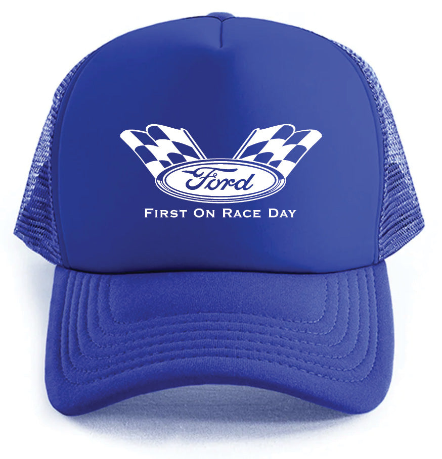 The Corsa Clothing Ford Racing Hat is a blue trucker style, featuring a white Ford logo between two checkered flags and "FIRST ON RACE DAY" printed below.
