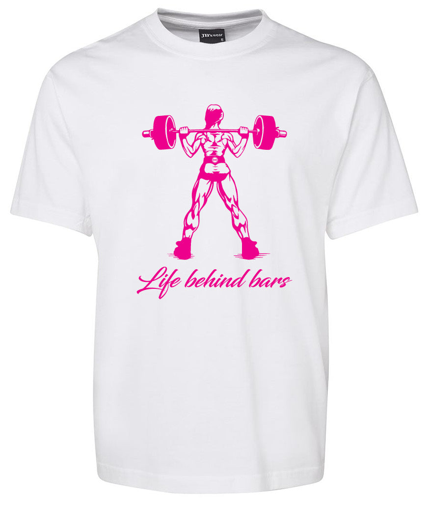 The Life Behind Bars Lifting Girl shirt by Corsa Clothing is a white tee with a pink graphic of a muscular girl lifting a barbell from behind and “Life behind bars” written in cursive below the image.