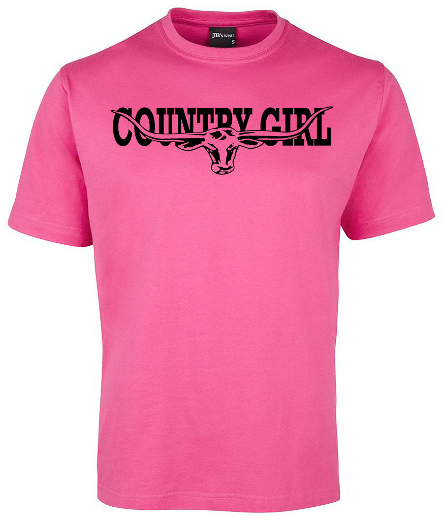 The Country Girl Cow Head Shirt by Corsa Clothing is a bright pink tee with "COUNTRY GIRL" in bold black letters and a graphic of a longhorn cow's head with large horns integrated into the text across the chest.