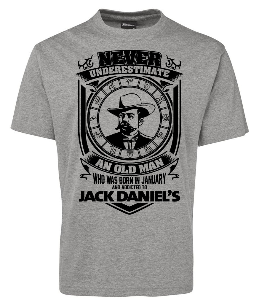 The Jack Daniel Avatar Logo Shirt by Corsa Clothing features a gray tee with a mustached man in a hat inside a clock face and the text: "Never underestimate an old man who was born in January and addicted to Jack Daniels.