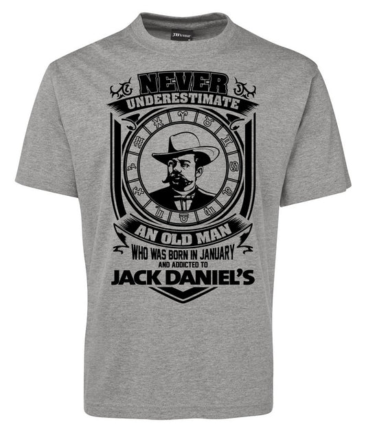 The Jack Daniel Avatar Logo Shirt by Corsa Clothing features a gray tee with a mustached man in a hat inside a clock face and the text: "Never underestimate an old man who was born in January and addicted to Jack Daniels.