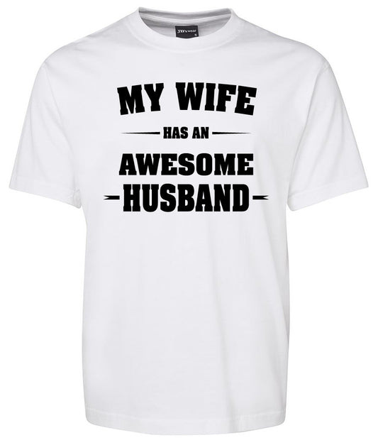 The Corsa Clothing MY WIFE HAS AN AWESOME HUSBAND Shirt is a white tee featuring bold black text proclaiming, "My wife has an awesome husband.