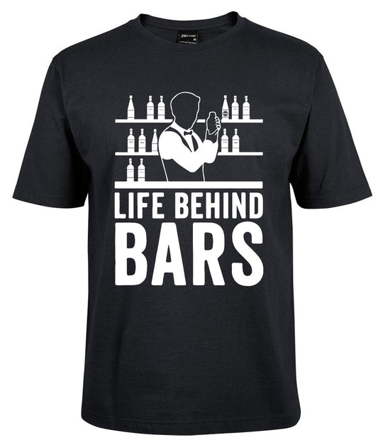 The Life Behind Bars Shirt by Corsa Clothing is a black tee with a bartender mixing drinks before shelves of bottles, and "LIFE BEHIND BARS" boldly printed in white.