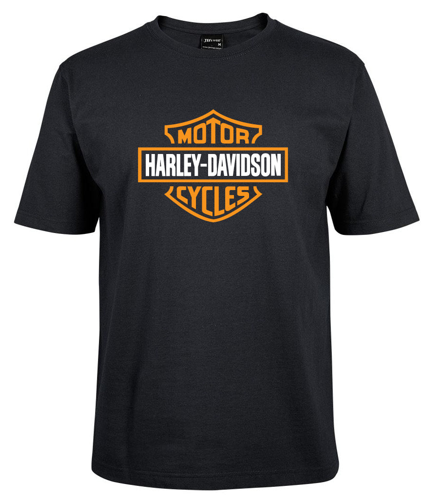The Corsa Clothing Harley-Davidson Bar & Shield Shirt Orange is a black tee featuring the iconic orange and white Harley-Davidson logo with "Motor" above and "Cycles" below in bold text inside a shield on the chest.