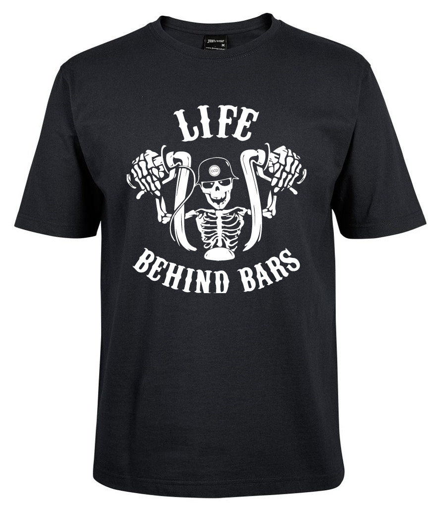 The Corsa Clothing Life behind bars Skeleton shirt in black features a white graphic of a helmeted skeleton gripping motorcycle handlebars, with “LIFE BEHIND BARS” printed above and below.
