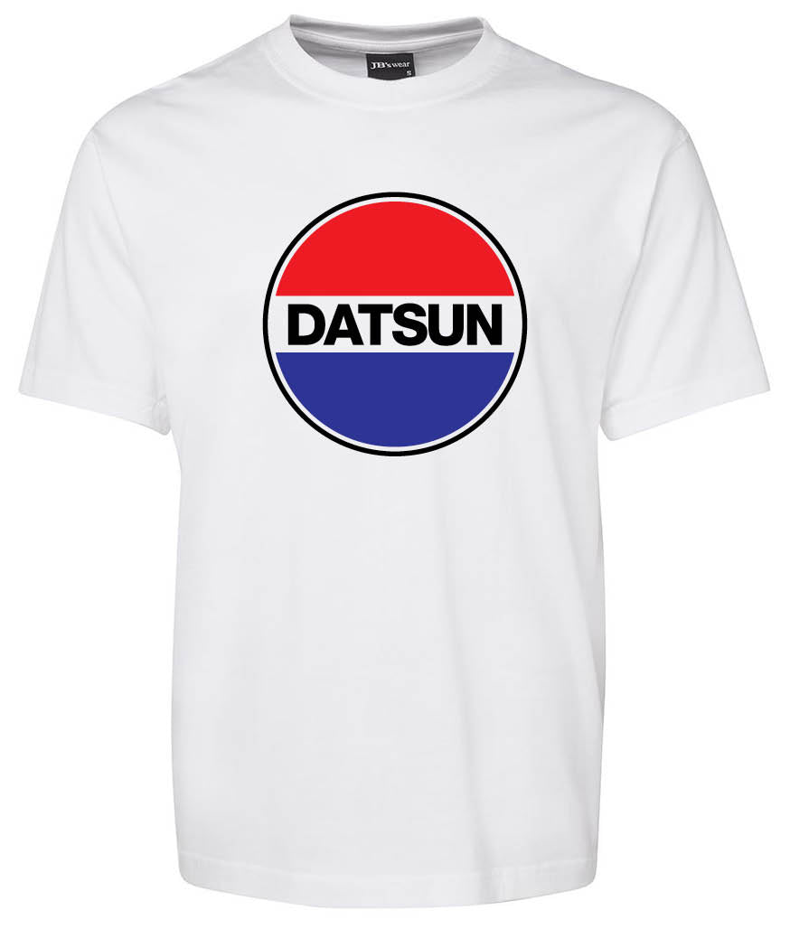 The Datsun Logo Shirt by Corsa Clothing is a white T-shirt with a bold central circular logo: "DATSUN" in black letters, divided by red on top, blue on the bottom, and separated by a white stripe.