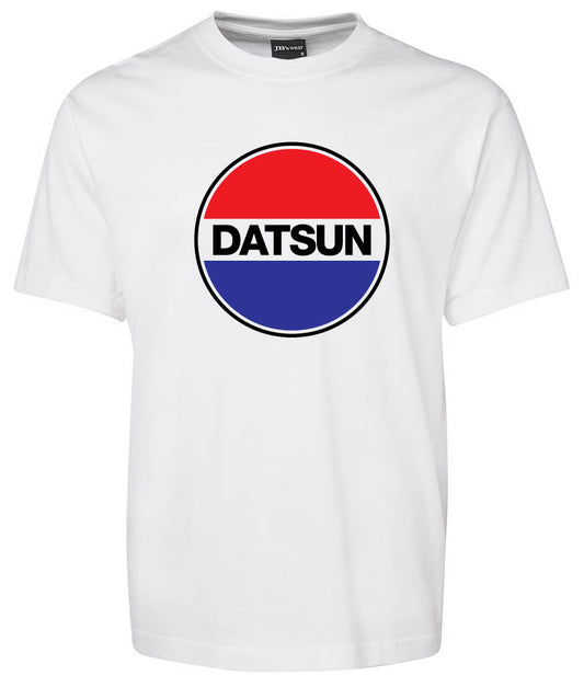 The Datsun Logo Shirt by Corsa Clothing is a white T-shirt with a bold central circular logo: "DATSUN" in black letters, divided by red on top, blue on the bottom, and separated by a white stripe.