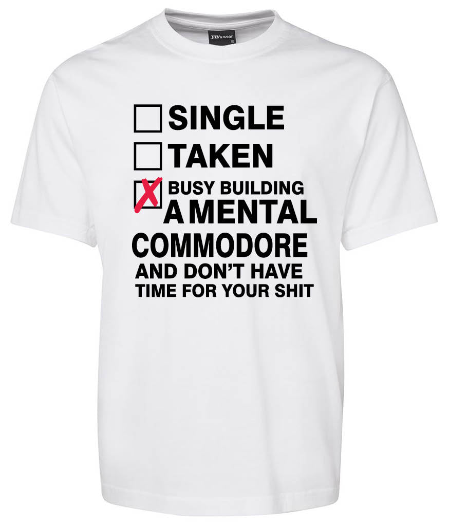 The COMMODORE Checkbox Shirt by Corsa Clothing is a white tee featuring checkboxes for Single, Taken, and a bold checked box reading "Busy building a mental Commodore and don’t have time for your shit" in black text.