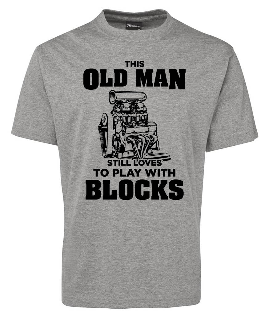 The Old Man Blocks Shirt by Corsa Clothing is a gray tee featuring a car engine graphic and bold black text: "This old man still loves to play with blocks.