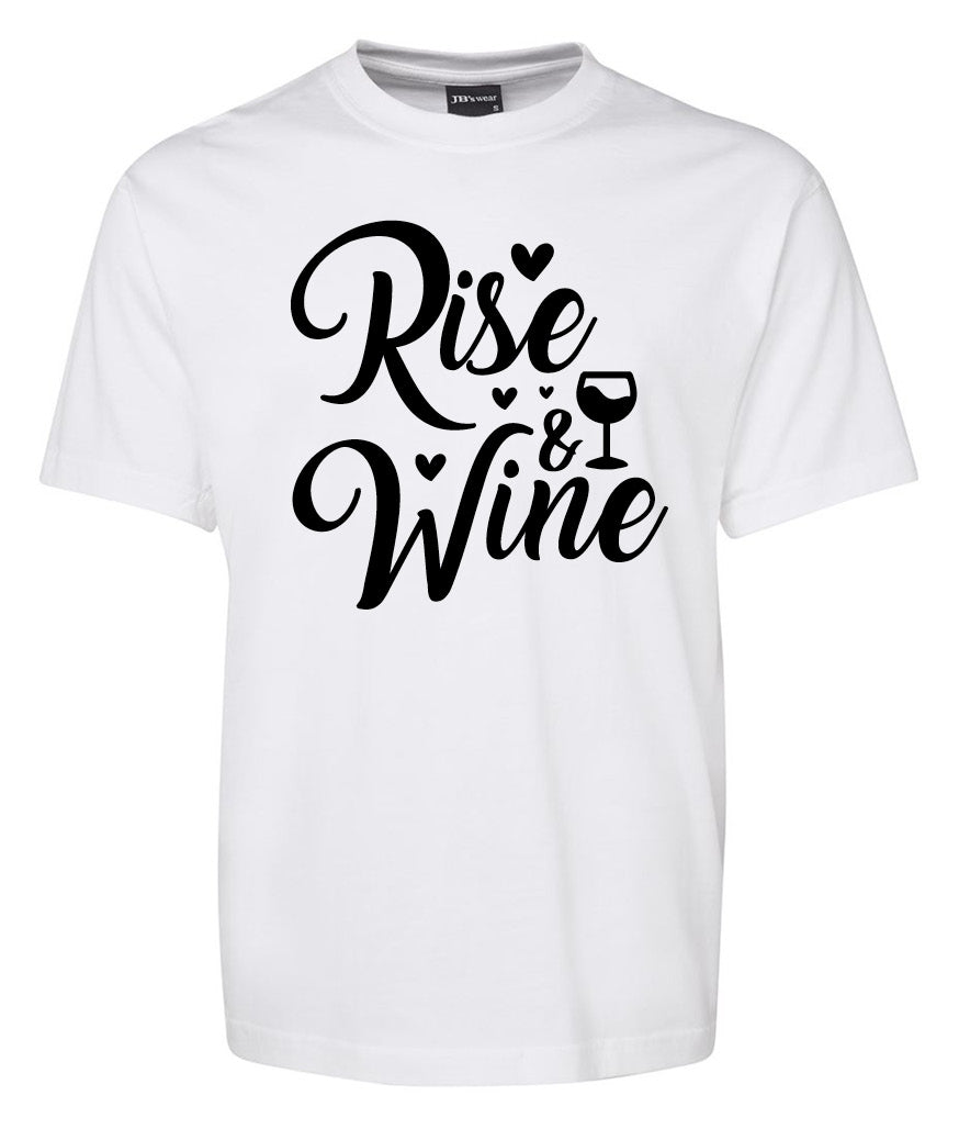 The Rise and Wine Shirt by Corsa Clothing is a white tee featuring "Rise & Wine" in black cursive, accented with small hearts and a wine glass illustration as the 'i' in "Wine.