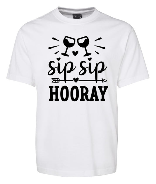 The Corsa Clothing Sip Sip Hooray Shirt is a white tee featuring two clinking wine glasses, small hearts, an arrow, and "sip sip HOORAY" text.