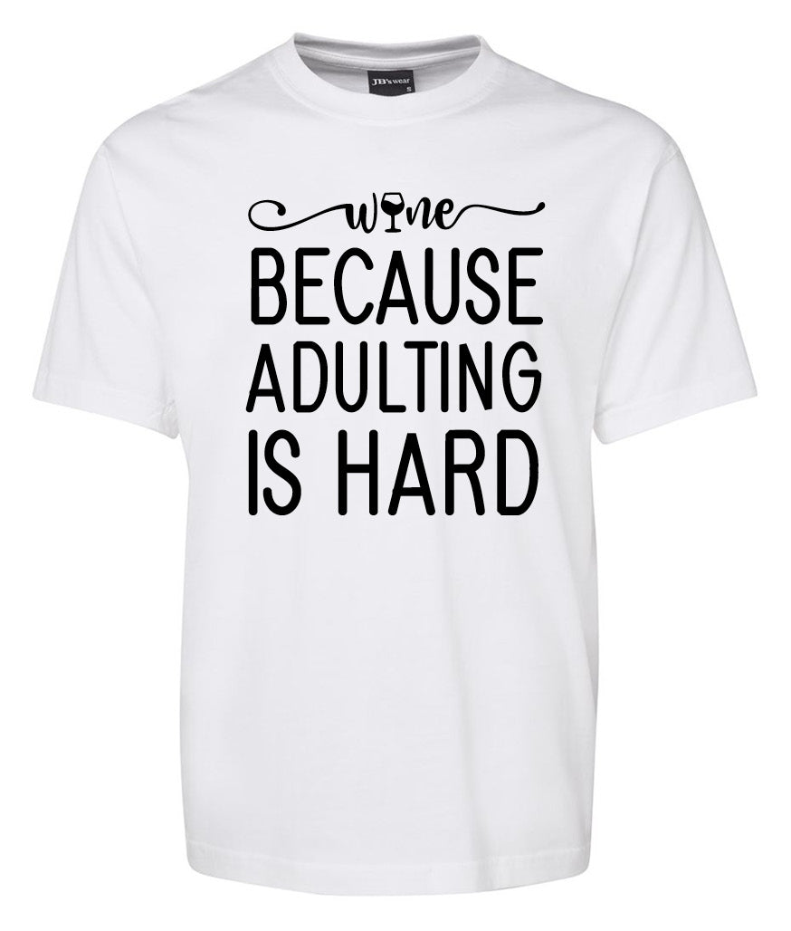 The Corsa Clothing Wine Because Adulting is Hard Shirt is a white tee with "Wine because adulting is hard" printed in large black letters on the front.