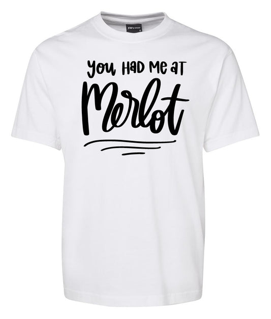The Corsa Clothing You had me at Merlot Shirt is a white T-shirt featuring the phrase "You had me at Merlot" in bold, playful black cursive and script fonts on the front.
