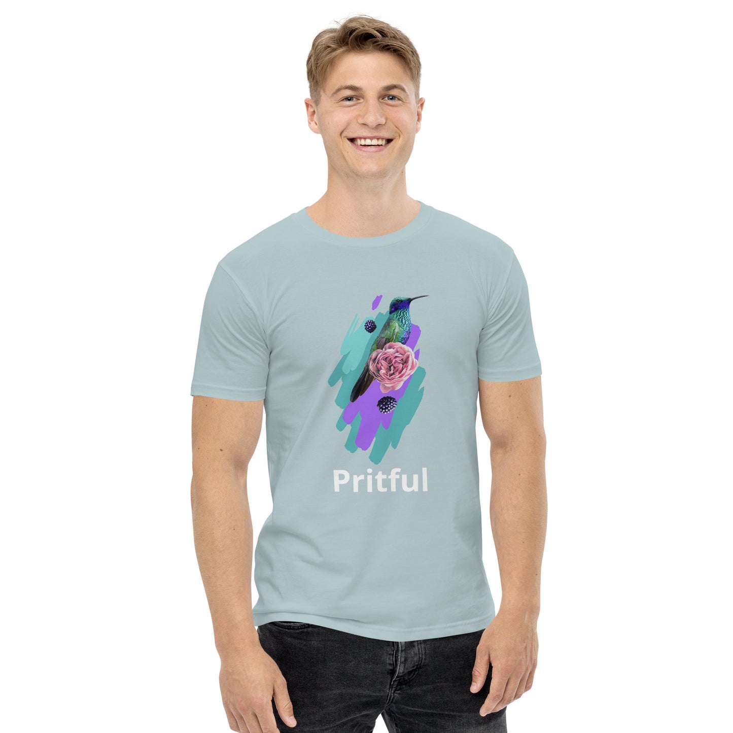 A smiling person wears Corsa Clothing's men's staple tee in light blue, made from soft cotton and featuring a vibrant hummingbird and rose design with "Pritful" below—ideal for Australia and New Zealand style enthusiasts.