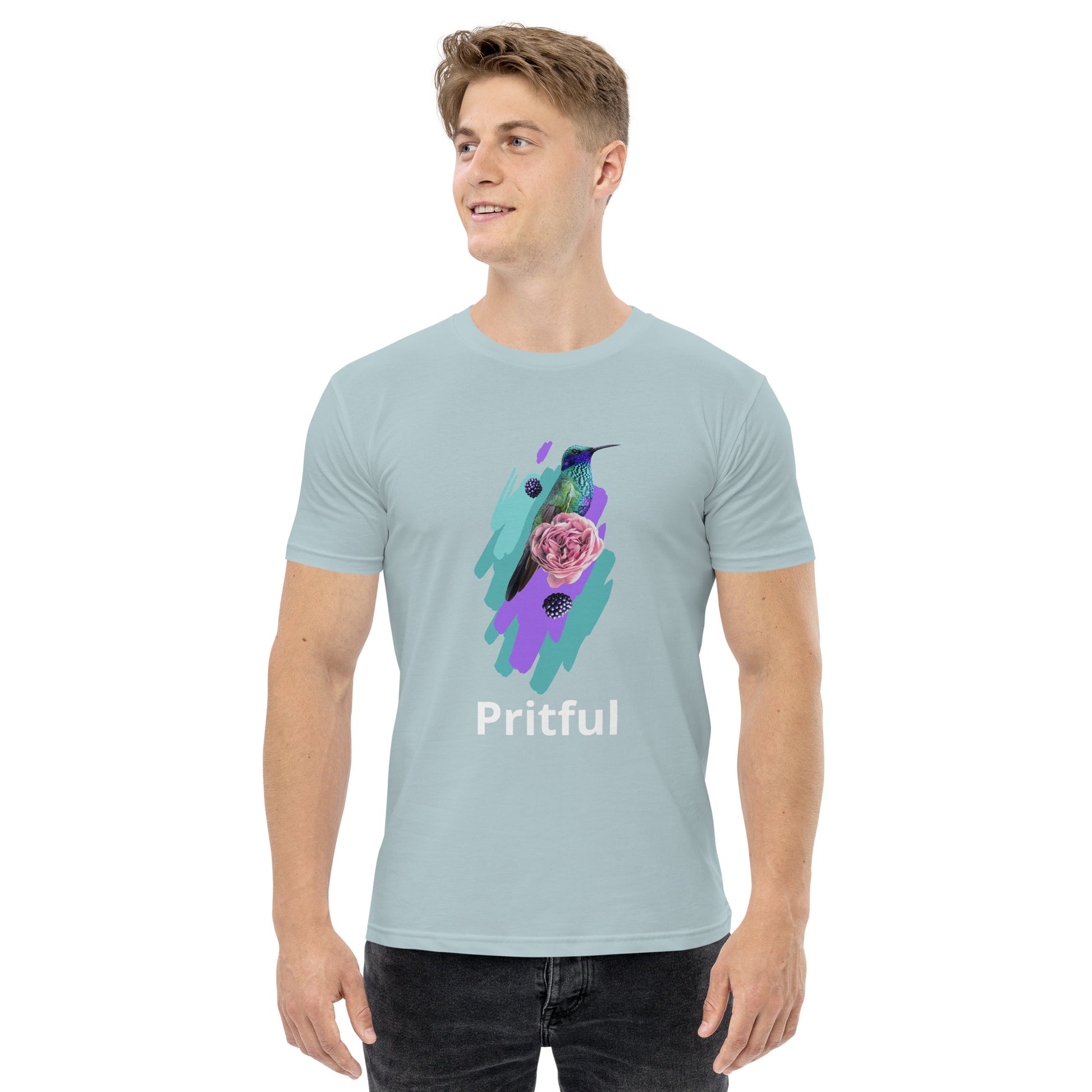 A man wears the Corsa Clothing men's staple tee—a light blue cotton t-shirt with a vibrant hummingbird and flower graphic above "Pritful." He stands smiling, looking to the side. Ideal for Australia and New Zealand style.